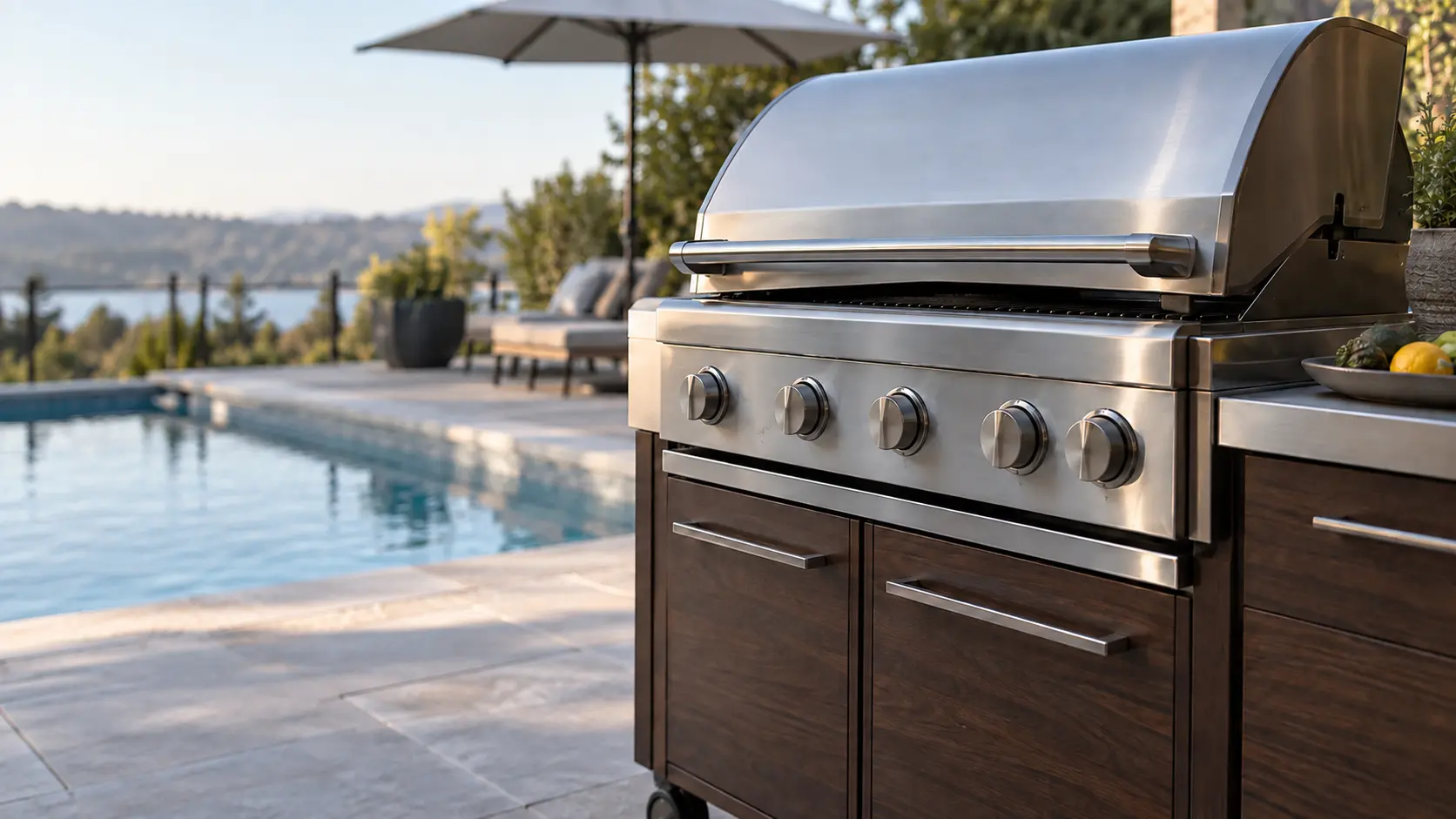 A pool deck with a cart grill and dark walnut cabinets, seen close at the grill's knobs.
